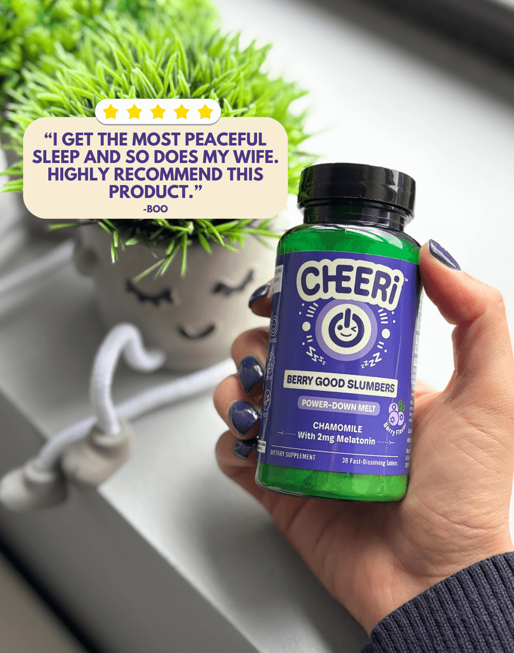 CHEERi Berry Good Slumbers supplement bottle held with a plant in the background, promoting restful sleep and relaxation.
