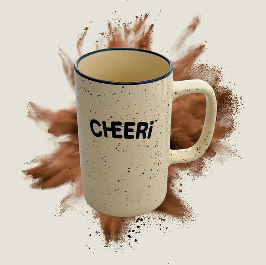 CHEERi Mug with speckled design, perfect for coffee or tea, set against a splash of cocoa powder.